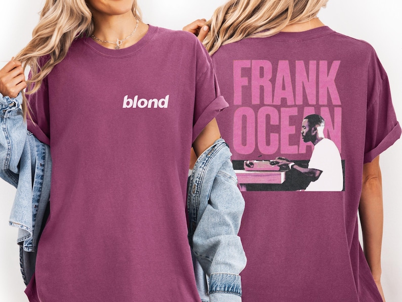 A person wearing a purple t-shirt with the text "blond" and a graphic of a person playing a keyboard.