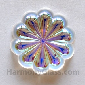 May include: A white iridescent glass flower with a scalloped edge. The flower has a starburst pattern in the center.