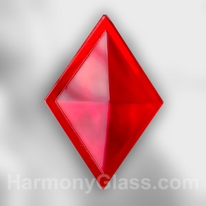 May include: A red glass pyramid with a diamond shape. The pyramid is made of clear glass with a red tint.