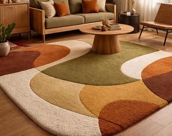 Könnte beinhalten: Ein ovaler Teppich mit einem großflächigen abstrakten Muster aus geschwungenen, überlappenden Formen in den Farben Creme, Olivgrün, Senfgelb, gebranntes Orange und Dunkelbraun. Der Teppich hat eine dicke, flauschige und strukturierte Oberfläche.