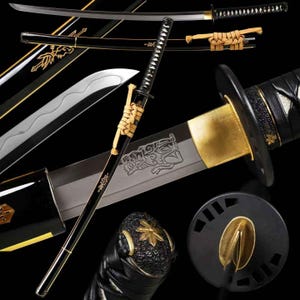 Puede incluir: Una katana negra con detalles dorados. La hoja plateada presenta un diseño grabado. La vaina negra está adornada con motivos florales dorados. La espada se muestra sobre un fondo negro. El mango está envuelto en un cordón beige.