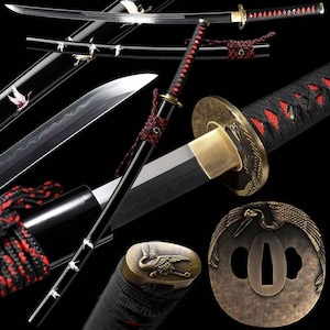 May include: A Japanese katana sword with a black lacquered scabbard and handle, accented with red and black cord wrapping. The blade is silver, and the guard and pommel feature a crane design. The sword is displayed against a black background.
