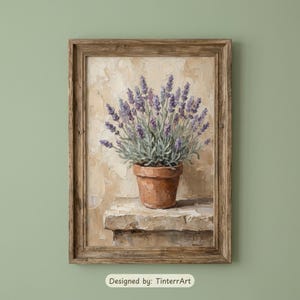 May include: A framed painting of a lavender plant in a terracotta pot. The lavender has purple flowers and green leaves. The painting is set against a textured beige background and is framed in a rustic brown wood. The text "Designed by: TinterrArt" is at the bottom.