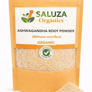 Puede incluir: Una bolsa de color beige de polvo de ra&iacute;z de Ashwagandha Saluza Organics. La etiqueta incluye el texto "Organic" y un sello circular "Certified Organic". Un peque&ntilde;o mont&oacute;n de polvo est&aacute; delante de la bolsa.