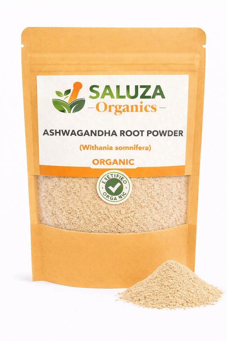 Puede incluir: Una bolsa de color beige de polvo de ra&iacute;z de Ashwagandha Saluza Organics. La etiqueta incluye el texto "Organic" y un sello circular "Certified Organic". Un peque&ntilde;o mont&oacute;n de polvo est&aacute; delante de la bolsa.