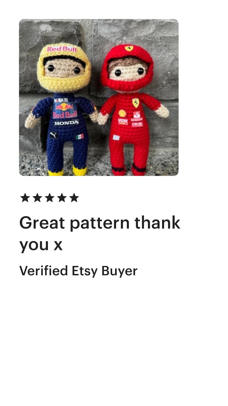 May include: Two crocheted dolls representing race car drivers. The left doll wears a yellow helmet and a dark blue racing suit with Red Bull and Honda branding. The right doll wears a red helmet and a red racing suit with Ferrari branding.