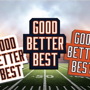 May include: Three signs with the words "GOOD BETTER BEST" in a football stadium setting. The signs are white, navy blue, and orange with black and orange text. The background shows a football field and stadium lights.