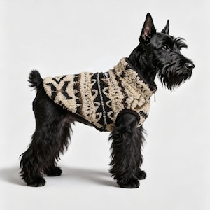 Peut inclure: Un terrier écossais noir portant un gilet en polaire à motifs beige et marron foncé. Le gilet présente un col montant, une tirette de fermeture éclair noire et un motif géométrique. Le chien a un pelage noir rêche, des oreilles pointues.