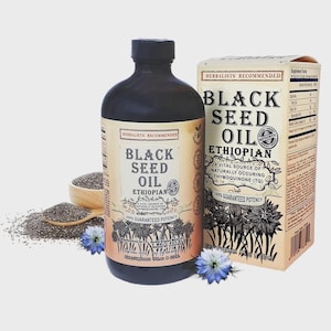 May include: A dark brown bottle of Black Seed Oil, with a matching box, and a wooden spoon with seeds. The label reads "Black Seed Oil Ethiopian" and "100% Guaranteed Potency". Blue flowers are scattered around the bottle.