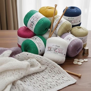 May include: A collection of colorful Tencel yarn skeins in shades of green, yellow, pink, white, and blue, with knitting needles, buttons, and a knitted shawl. The yarn labels read "Nihao Tencel Yarns."