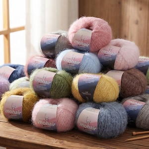 May include: A collection of colorful mohair yarn balls in shades of pink, blue, green, yellow, and brown, stacked on a wooden surface. Each ball has a label with the word "mohair". The scene is illuminated by natural light.