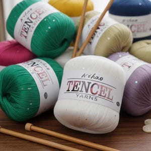 May include: A collection of colorful yarn skeins, including green, white, purple, and yellow, with the text "Tencel Yarns" on the labels. Wooden knitting needles are also visible. The yarn is embellished with sequins.