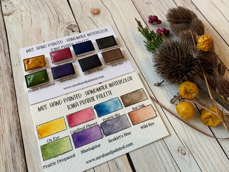 May include: Two cards showing a watercolor paint palette with the title "Mrs. Hand Painted - Handmade Watercolor Iowa Prairie Palette". The palette includes colors like "Prairie Dropseed", "Blazingstar", "Reakirt's Blue", "Wild Rye", "Ox Eye", "Cardinal Flower", "Prairie Sky", "Bur Oak".