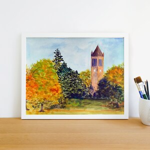 K&ouml;nnte beinhalten: Aquarellmalerei eines hohen Ziegelturms mit einem spitzen Dach, umgeben von B&auml;umen mit Herbstlaub. Die B&auml;ume sind in Gr&uuml;n-, Gelb- und Oranget&ouml;nen gehalten. Der Himmel ist hellblau mit einigen Wolken.