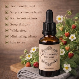 Puede incluir: Una botella de vidrio marrón de tintura de fresa silvestre con un cuentagotas, sobre un paño gris. La etiqueta dice "Wild Strambery Tincture". Fresas frescas y flores blancas rodean la botella. El texto enumera 7 razones para usar la tintura.