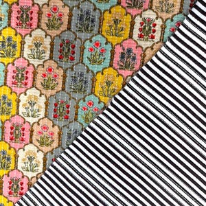 Peut inclure: Un patchwork de tissu à motifs avec des motifs floraux de différentes couleurs, dont le jaune, le rose et le gris, avec un tissu rayé noir et blanc contrastant. Le motif floral est dans un design en arc répétitif.