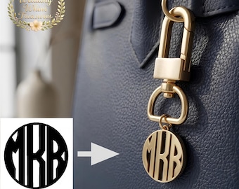 Op de afbeelding: Goudkleurige monogram tasbedel met de initialen "MRR" in een cirkelvormig ontwerp. De bedel is bevestigd aan een goudkleurige sluiting, hangend aan een marineblauwe handtas. De afbeelding bevat ook een logo met de tekst "Wedding Whim Treasures".