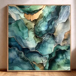 May include: Abstract art print in a wooden frame. The artwork features flowing layers of teal, blue, and green hues with gold accents. The design resembles a landscape or geological formation. The frame is a light brown color.