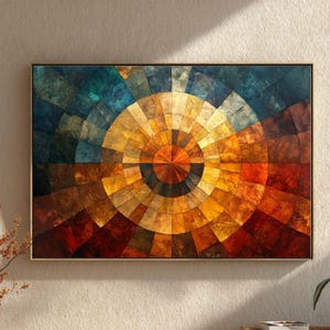 May include: Abstract geometric wall art featuring a circular design with a spectrum of colors. The artwork showcases a mosaic-like pattern with shades of blue, orange, yellow, and brown, framed in a simple wooden frame. The design evokes a sense of depth and texture.