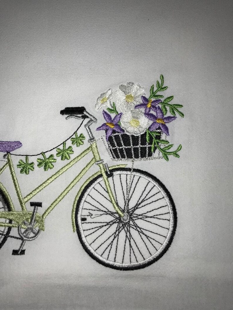 May include: A green bicycle with a basket full of white and purple flowers. The bicycle has a green frame and white wheels.