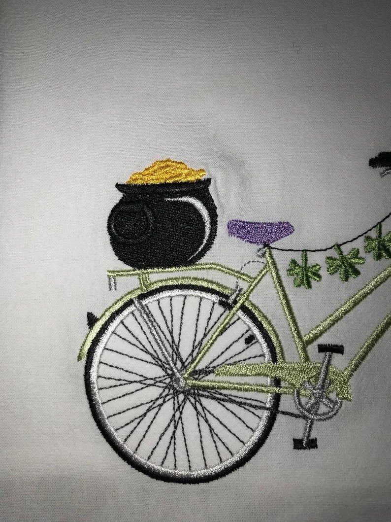 May include: A green bicycle with a pot of gold on the back rack. The bicycle has a purple seat and a string of shamrocks hanging from the handlebars.