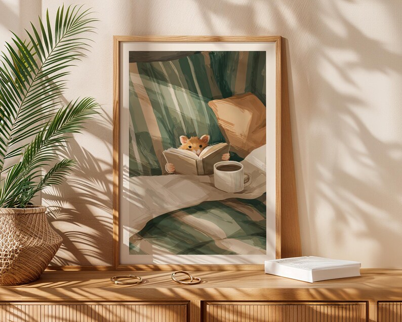 Pu&ograve; includere: Una stampa artistica incorniciata raffigura una scena accogliente di un piccolo criceto che legge un libro a letto. L'opera presenta una coperta a righe verdi e bianche, un cuscino beige e una tazza di caff&egrave; bianca. La stampa &egrave; esposta su una superficie di legno.