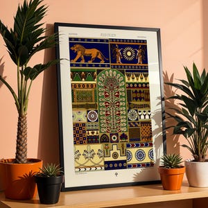May include: A framed Assyrian art print with a lion, sun, and geometric designs in blue, green, and gold. The print is on a wooden surface with potted plants in orange, black, and white, creating a decorative display. The print is in a black frame.