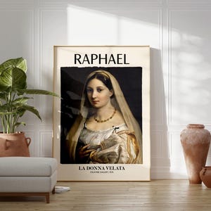May include: A framed art print of Raphael's "La Donna Velata" featuring a portrait of a woman in a white veil and dress. The print is displayed on a wooden floor, next to a potted plant, a footstool, and terracotta vases.