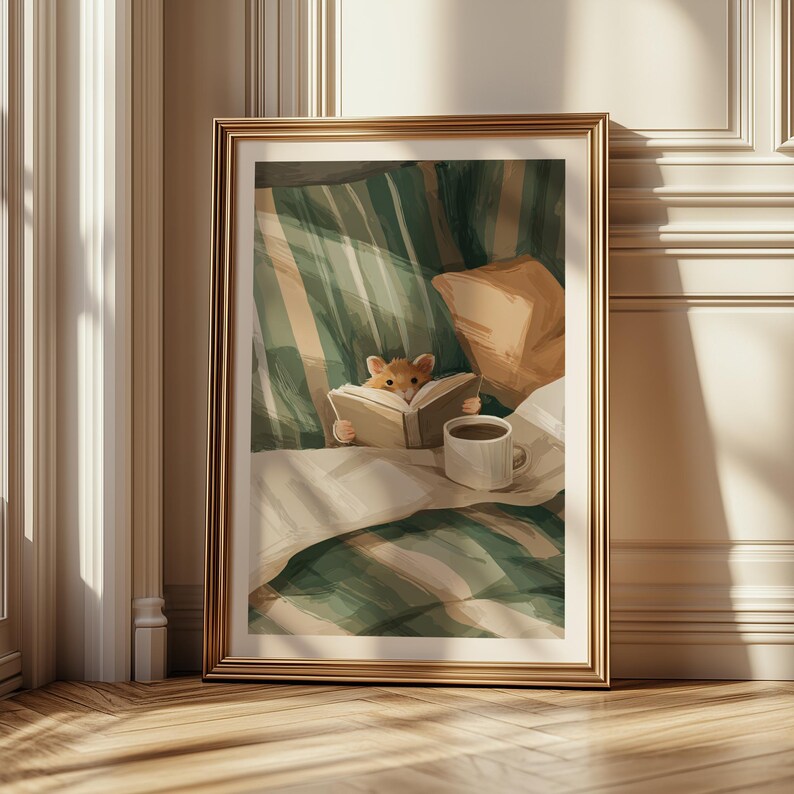 Pu&ograve; includere: Una stampa artistica incorniciata raffigura un criceto che legge un libro a letto. L'opera d'arte presenta una cornice dorata, una coperta a righe verdi e bianche, un cuscino beige e una tazza di caff&egrave; bianca. L'estetica generale &egrave; calda e invitante.