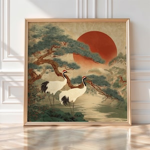 May include: Framed art print featuring two Japanese cranes with red crests, standing near a body of water. The artwork has a vintage aesthetic, with a large red sun in the background and green foliage.