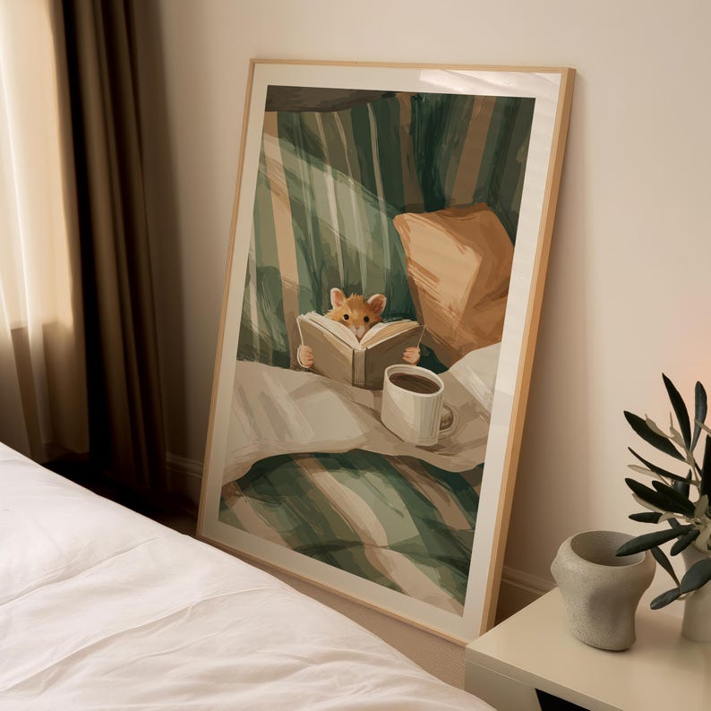 Pu&ograve; includere: Una stampa artistica incorniciata raffigura un criceto che legge un libro a letto. L'illustrazione presenta una tazza di caff&egrave;, cuscini e uno sfondo a righe verdi e bianche. L'opera d'arte &egrave; in una cornice di legno.