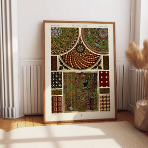 May include: A framed print displaying medieval artwork with detailed patterns in green, red, and gold. The print includes the text "MOYEN-AGE" and "MIDDLE AGES". The artwork is displayed on a white wall.