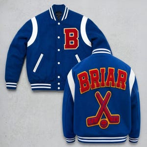 May include: A blue varsity jacket featuring white sleeves, a red letter B on the front, and the text BRIAR in red with a crossed hockey stick and puck graphic on the back. The jacket has a snap-button closure and striped ribbed trim.