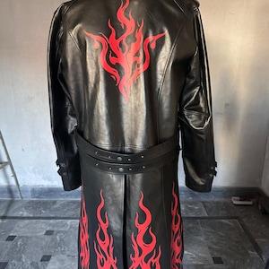 Pu&ograve; includere: Cappotto lungo in pelle nera con disegni di fiamme rosse sulla schiena e sulla parte inferiore anteriore. Il cappotto ha una cintura e finiture rosse. Il cappotto lungo arriva sotto le ginocchia.