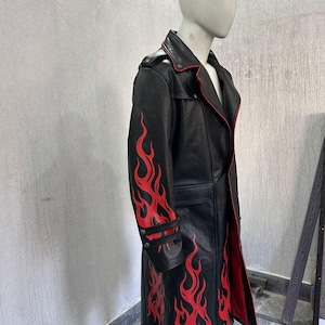 Pu&ograve; includere: Cappotto lungo in pelle nera con disegni di fiamme rosse sulle maniche e sul fondo. Il cappotto ha fodera e finiture rosse ed &egrave; esposto su un manichino. Presenta chiusura con bottoni e colletto a revers.