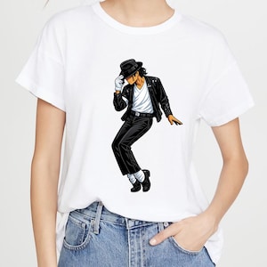 May include: White t-shirt featuring a cartoon illustration of a person in a black outfit, black hat, and white gloves, striking a dance pose. The person is wearing a black jacket with silver sequins, black pants, and black shoes.