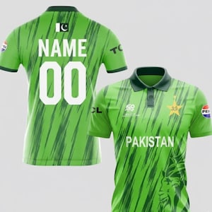Può includere: Due maglie da cricket verdi e bianche. Una maglia ha la scritta "NAME" e il numero "00" sul retro. L'altra maglia ha la scritta "PAKISTAN" sul davanti, insieme a un logo a stella e mezzaluna.