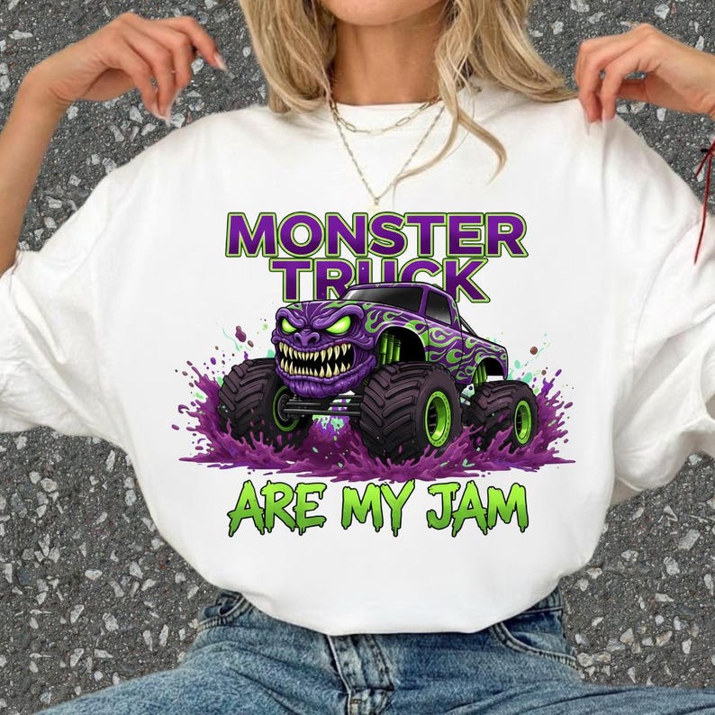 May include: White t-shirt featuring a graphic of a purple monster truck with green accents and large tires. The text "MONSTER TRUCK" is above the truck, and "ARE MY JAM" is below it, all in green and purple.