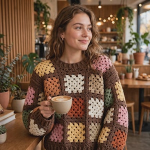 Peut inclure: Un pull à manches longues en fil marron composé d'un patchwork de carrés granny multicolores dans des tons jaune, rose, orange, vert et crème. Le vêtement présente une encolure ronde et un aspect texturé réalisé au crochet à la main.