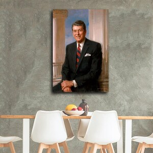 Puede incluir: Un retrato de un hombre con un traje a rayas negras con una corbata a rayas rojas y azules. La pintura representa al hombre sentado, con un pa&ntilde;uelo blanco, sobre un fondo de columnas cl&aacute;sicas y un cielo azul.