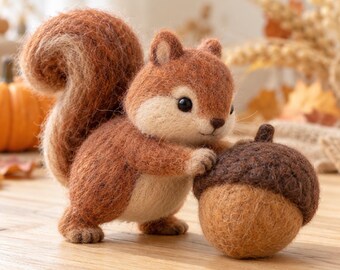 May include: A needle-felted squirrel figurine crafted from brown and cream wool fibers. The squirrel has a large, bushy tail and is positioned standing next to a round, brown wool-felted acorn with a textured cap.