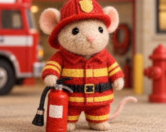 May include: A needle-felted mouse figurine dressed as a firefighter, wearing a red helmet with a yellow emblem and a red jacket and pants with yellow reflective stripes. The mouse holds a small red fire extinguisher with a black hose and nozzle.