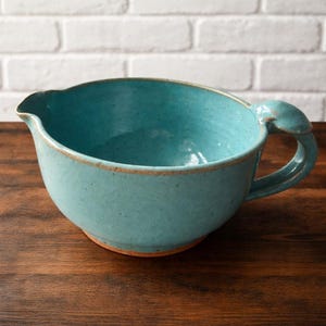 Bol de cerámica vintage DW firmado, con asa de concha marina, color verde azulado.