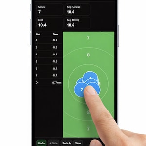 Könnte beinhalten: Ein Smartphone-Bildschirm zeigt eine App zur Luftgewehrwertung. Die App zeigt eine Zielscheibe mit Schussgruppen und Wertungsdaten. Der Bildschirm zeigt den Text "Air Rifle Scoring" und "Series 1 (Shot 1-10)". Ein Finger berührt den Bildschirm.