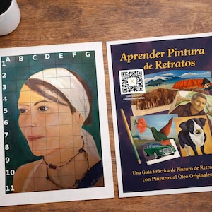 Könnte beinhalten: Zwei Kunst-Anleitungsblätter auf einer Holzoberfläche. Eines zeigt ein Raster über einem Porträt, das andere den Text "Aprender Pintura de Retratos" und Illustrationen. Eine Kaffeetasse, ein Notizbuch und ein Pinsel sind ebenfalls sichtbar.