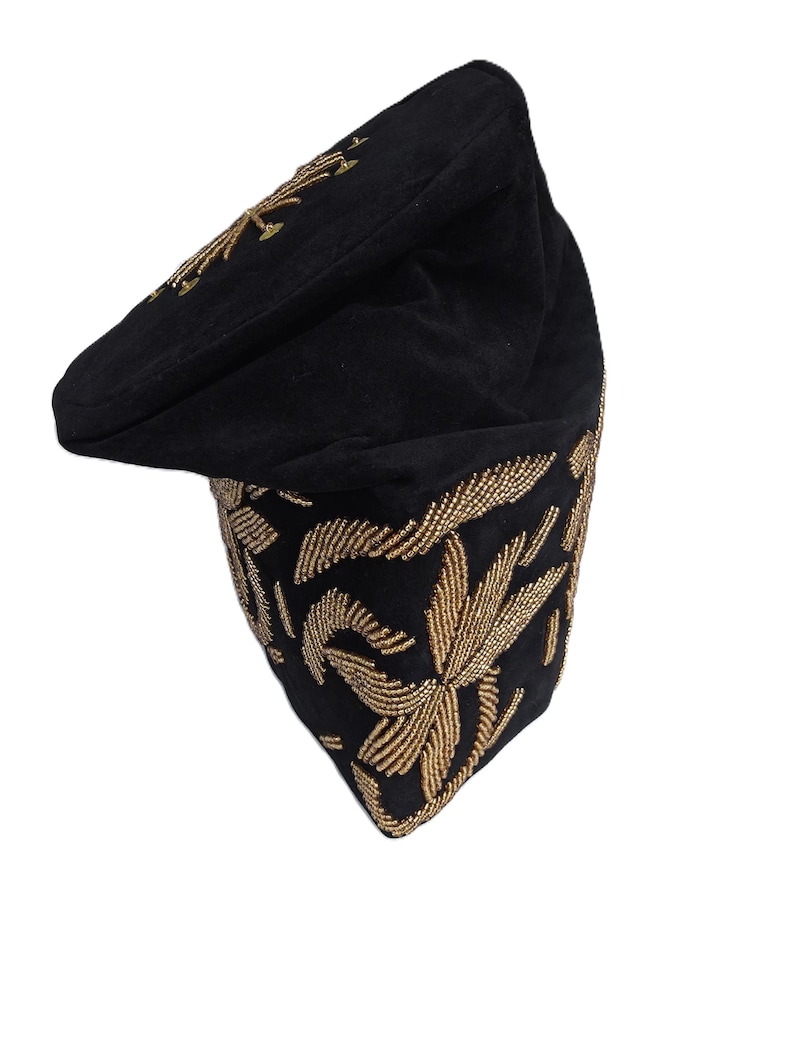 May include: A black cap with gold-colored embroidered floral designs. The cap features a curved brim and is decorated with intricate gold beadwork. The cap's design includes a gold floral pattern on the top and around the base.