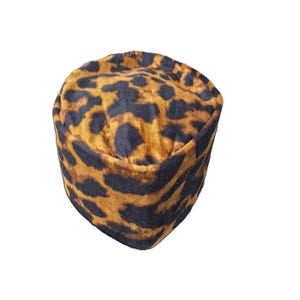 May include: A leopard print hat in shades of brown and black. The hat is a rounded, close-fitting style, with a soft, textured appearance. The animal print pattern covers the entire surface of the hat.