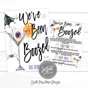 May include: Two Halloween-themed printable signs with the text "We've Been Boozed" and "You've Been Boozed". The first sign features a martini glass with an eyeball and spider. The second sign has instructions.