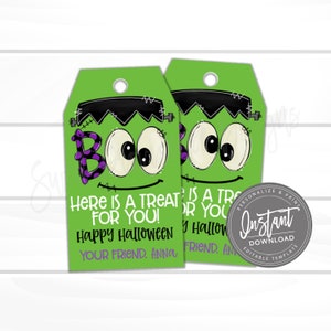 Pode incluir: Duas etiquetas de presente retangulares verdes com um rosto de monstro Frankenstein, cabelo preto, olhos brancos grandes e um gr&aacute;fico BOO roxo com bolinhas. O texto diz HERE IS A TREAT FOR YOU! HAPPY HALLOWEEN YOUR FRIEND, ANNA.