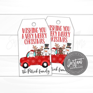 May include: Two white rectangular gift tags with a hole at the top. The text reads WISHING YOU A VERY MERRY CHRISTMAS in red. Below is a red truck with polka dots carrying a Santa Claus, a reindeer, and a snowman. The text the Patrick family is at the bottom.